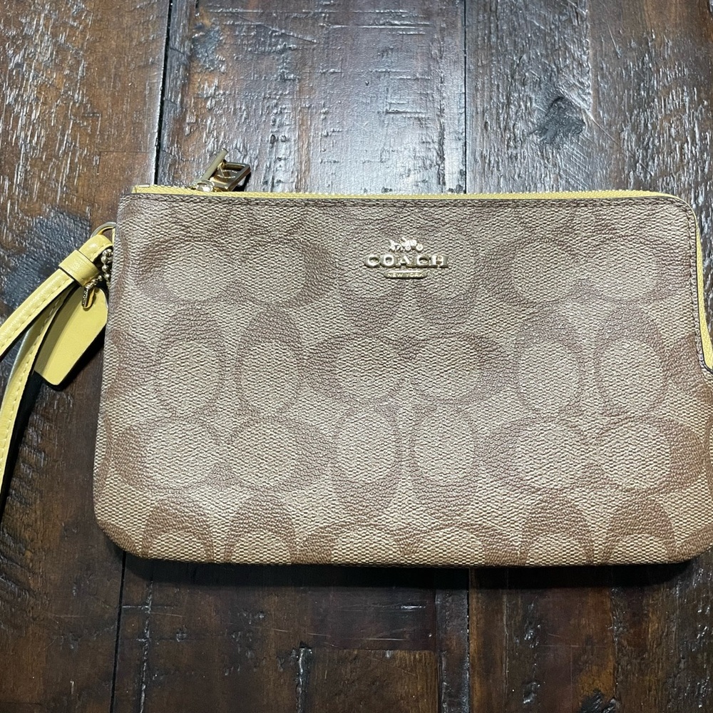 Double zippered Coach wristlet in a larger size.